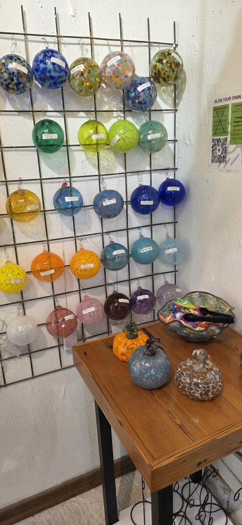 A wall with samples of blown glass colors 